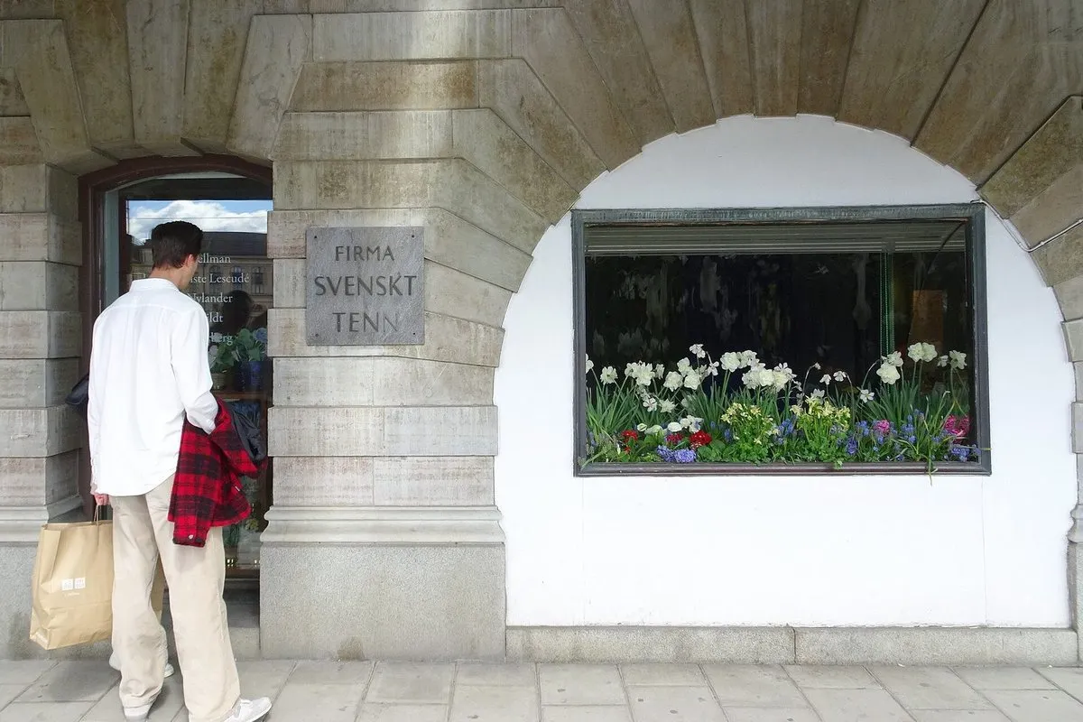 The entrance to Svenskt Tenn on Strandvägen 5, with a sign and a shop window featuring flowers