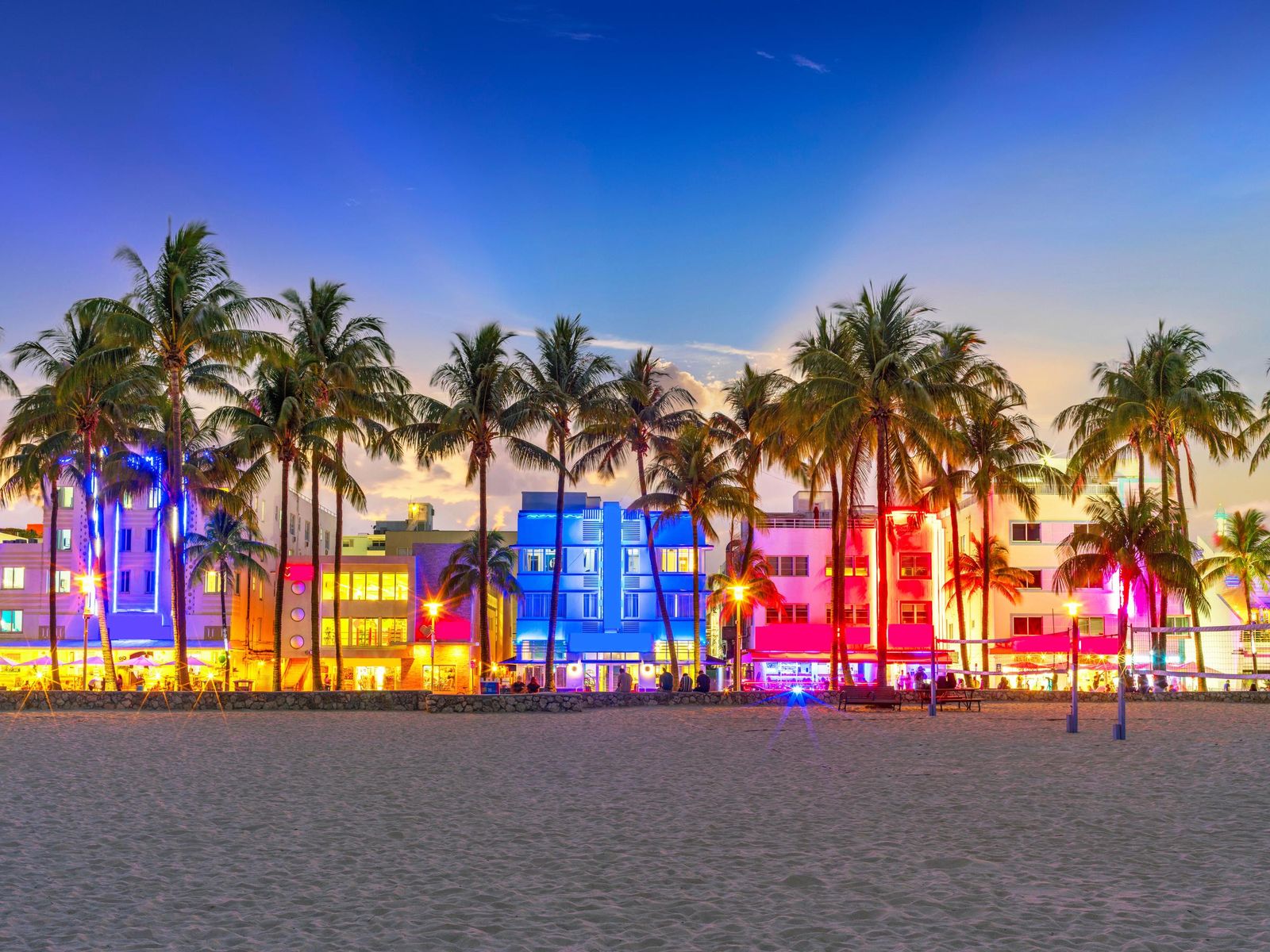 Ocean Drive's Art Deco hotels lit up at dusk, South Beach