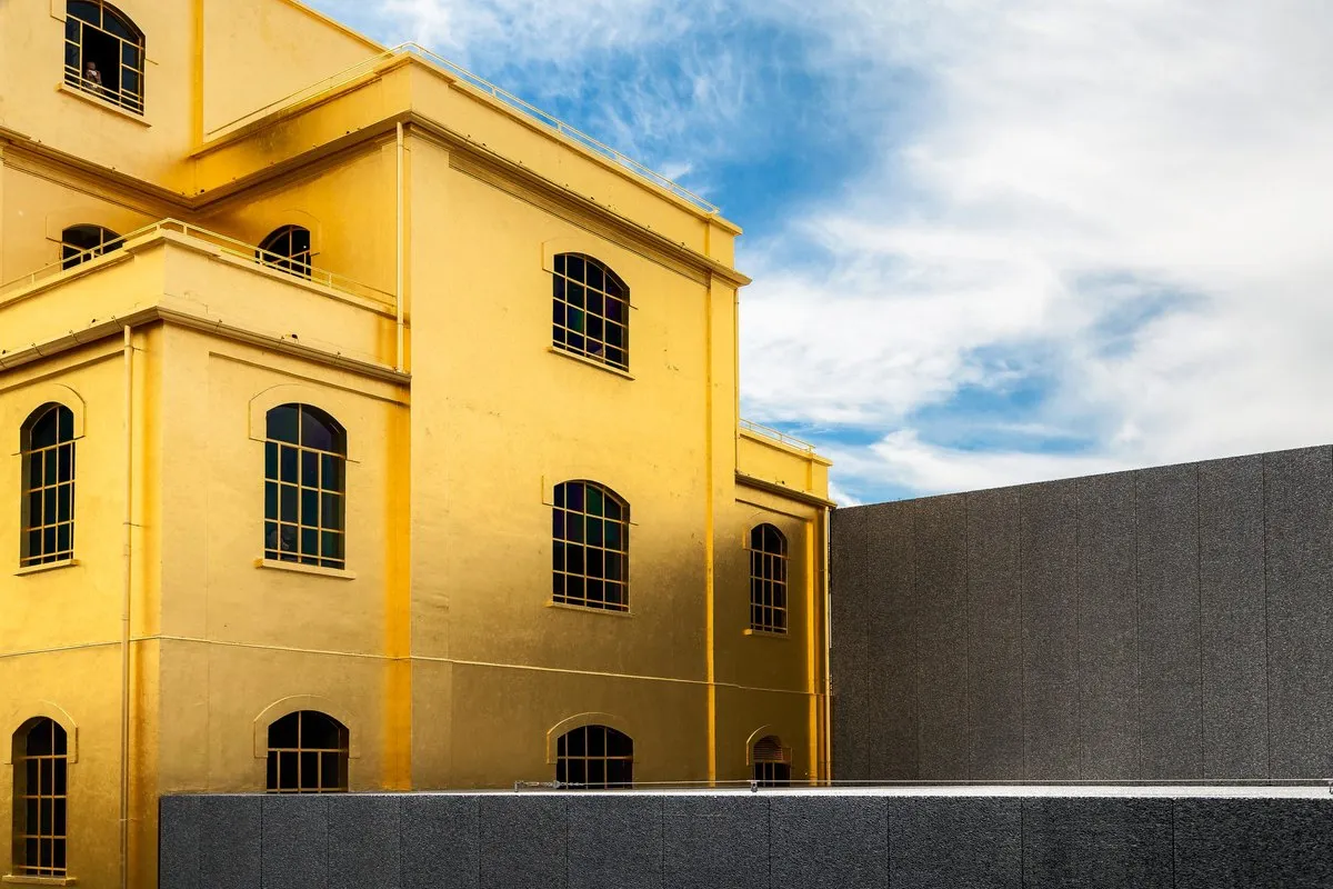 The Haunted House at Fondazione Prada in Milan, a four-storey former distillery building clad in 24-carat gold leaf, against a blue sky