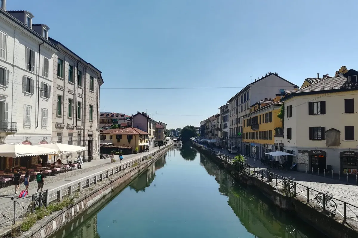 The Naviglio Grande in Milan, the canal running between pastel houses and café terraces on the towpaths