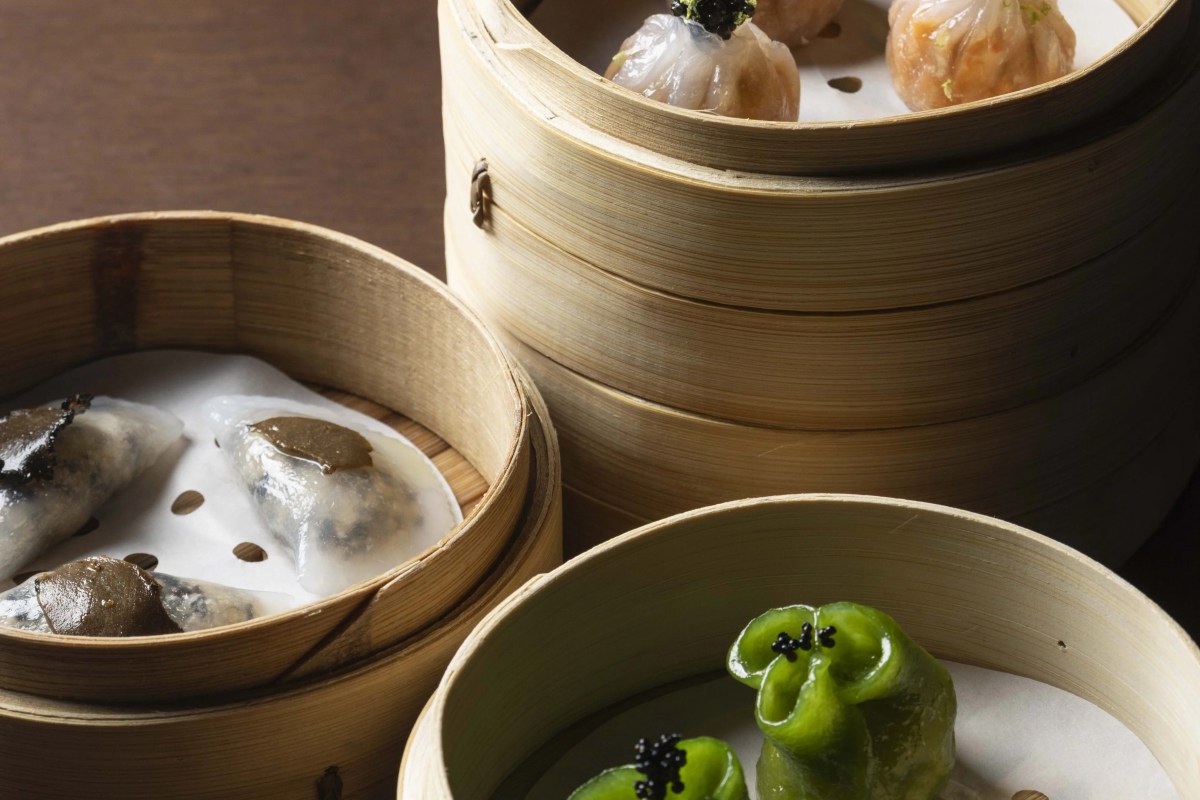 Bamboo steamer baskets with assorted dim sum dumplings, including shrimp, truffle, and green herb-wrapped varieties