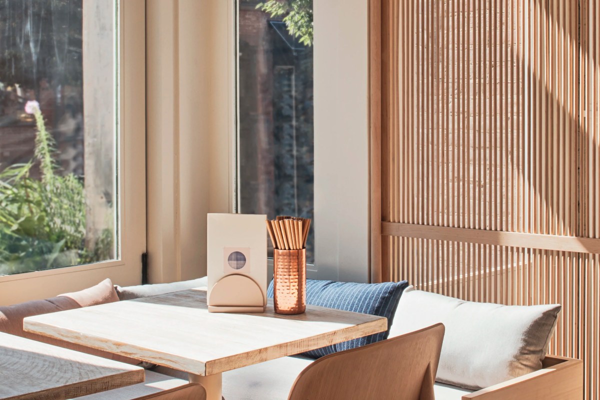 Cozy window-side dining table with cushioned bench and slatted wood screen