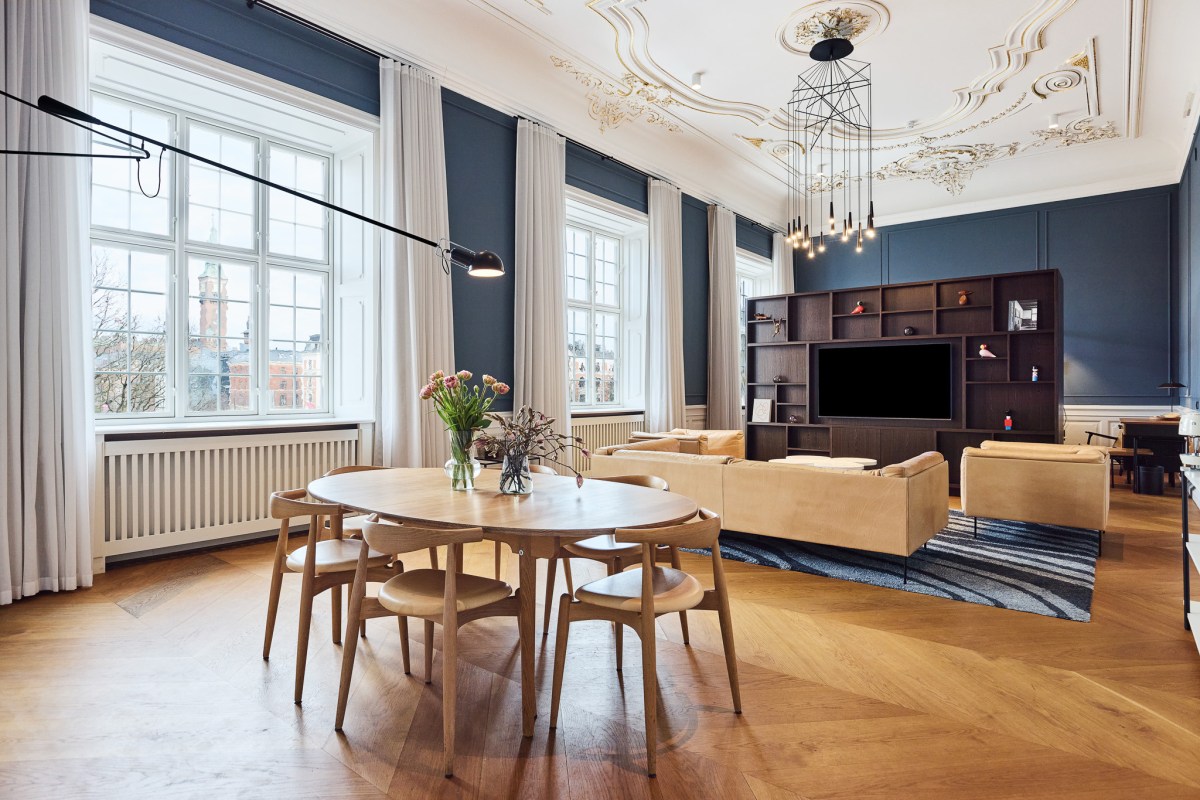 Suite living area with ornate ceiling, blue walls, dining table and sofa
