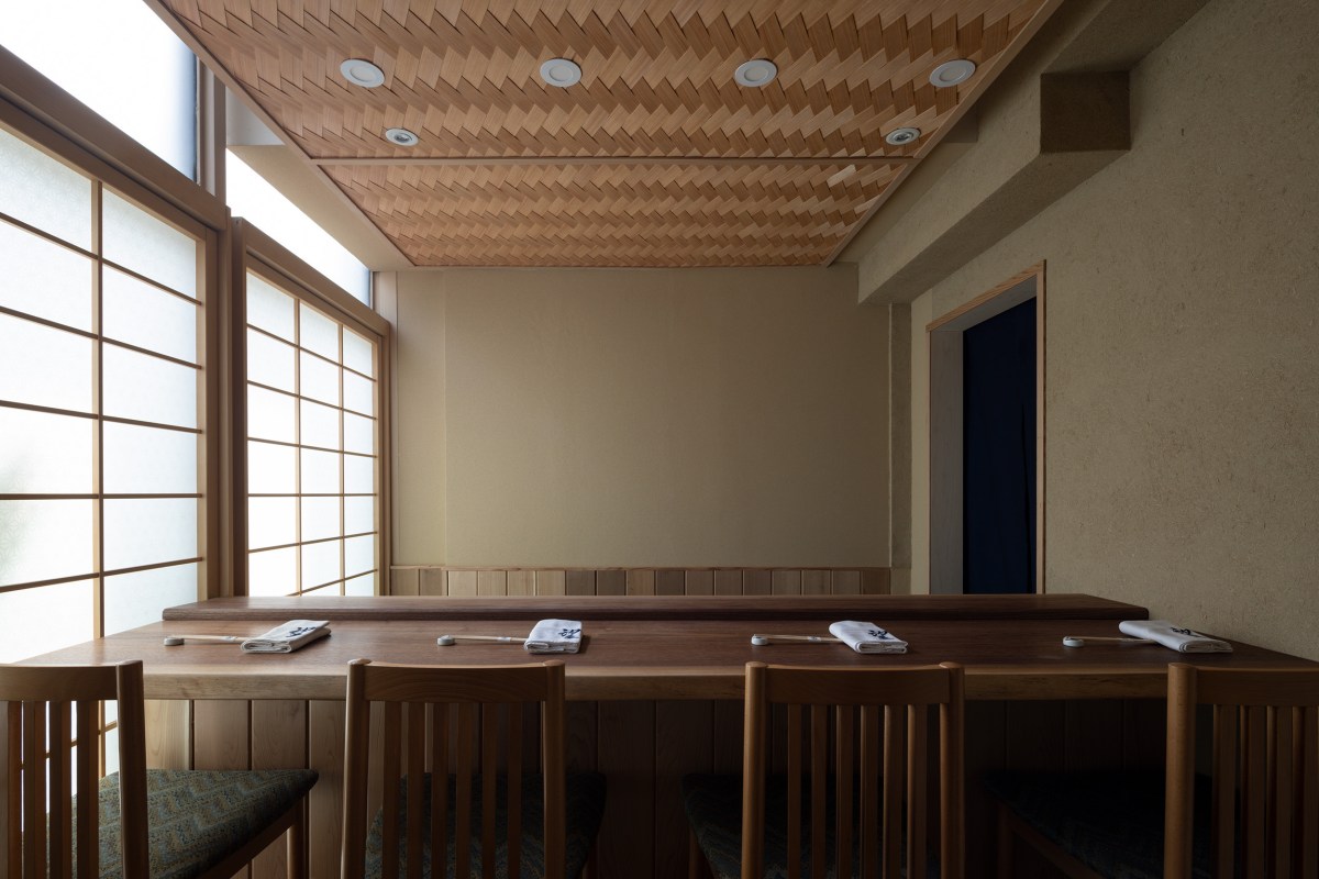 Minimalist dining counter with wooden chairs, shoji screens, and a woven wood ceiling