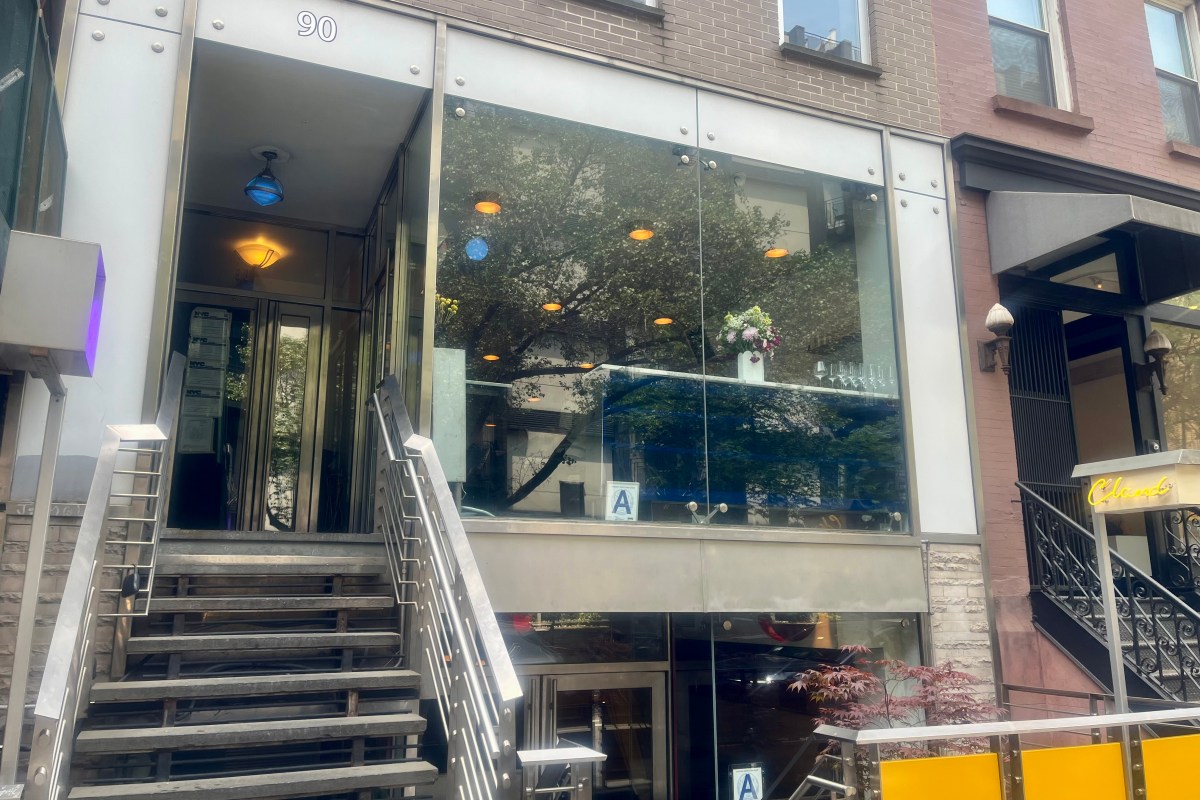 Exterior of Penny restaurant in NYC, glass storefront with staircase entrance at 90