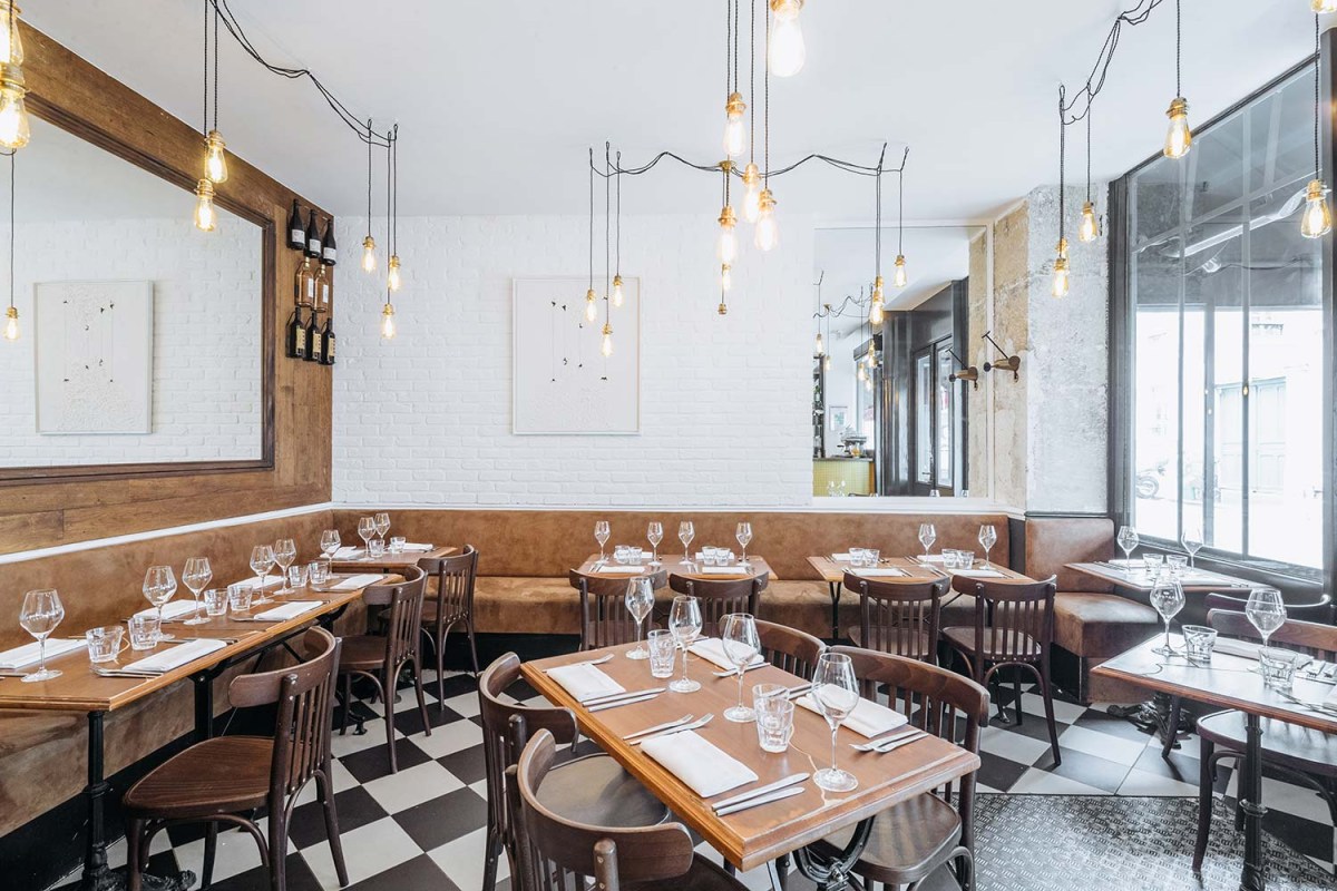 Dining room with checkered floor, wood tables, pendant bulbs and large window
