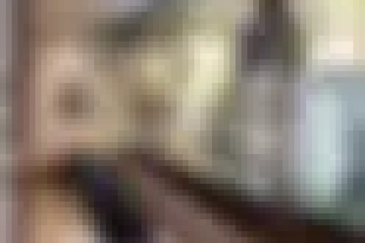 Blurry interior view of dining room with framed pictures on wall