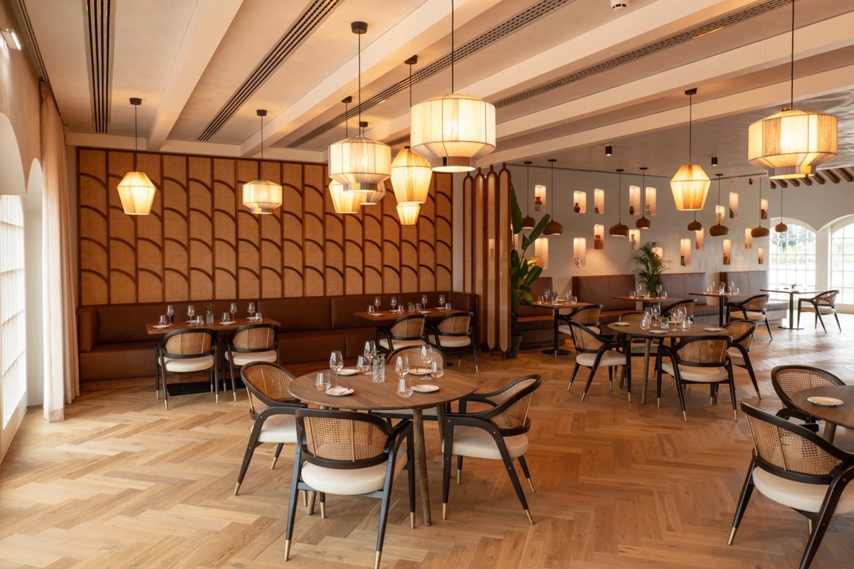 Spacious restaurant with pendant lantern lights, patterned wall panel, dining tables and arched windows at Quinta do Paral