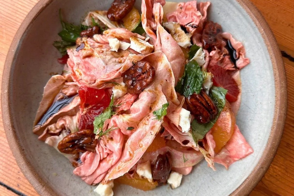 Colorful salad with radicchio, citrus segments, candied pecans, cheese and mint on a plate