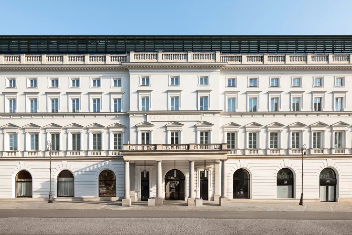 Frontal view of the Raffles Europejski Warsaw's white neoclassical façade with entrance and arched windows