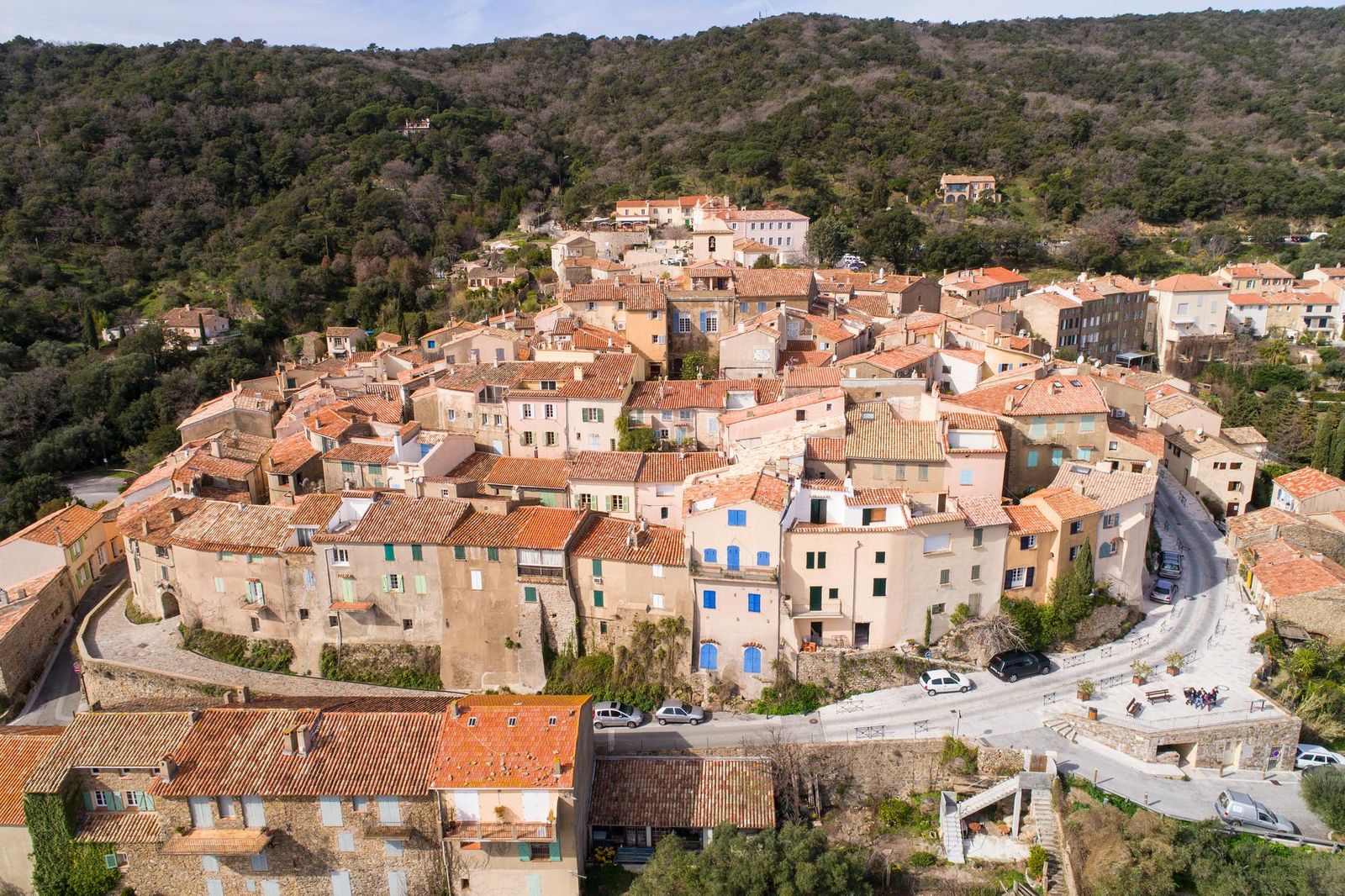 Ramatuelle from the air: the old village's stone houses stacked on the hillside above the woods
