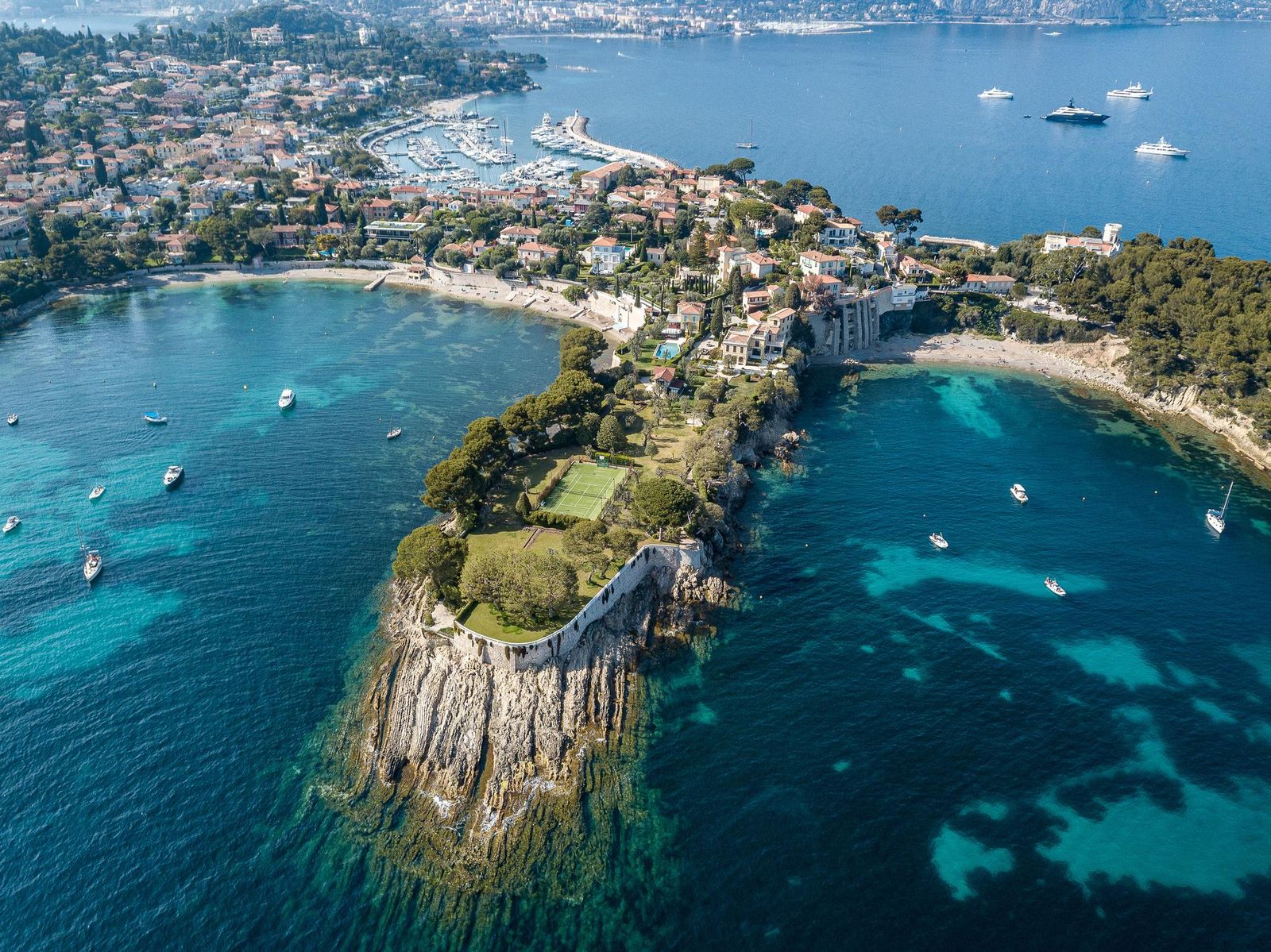 Saint-Jean-Cap-Ferrat from the air: the village, the harbour and a rocky point in clear water