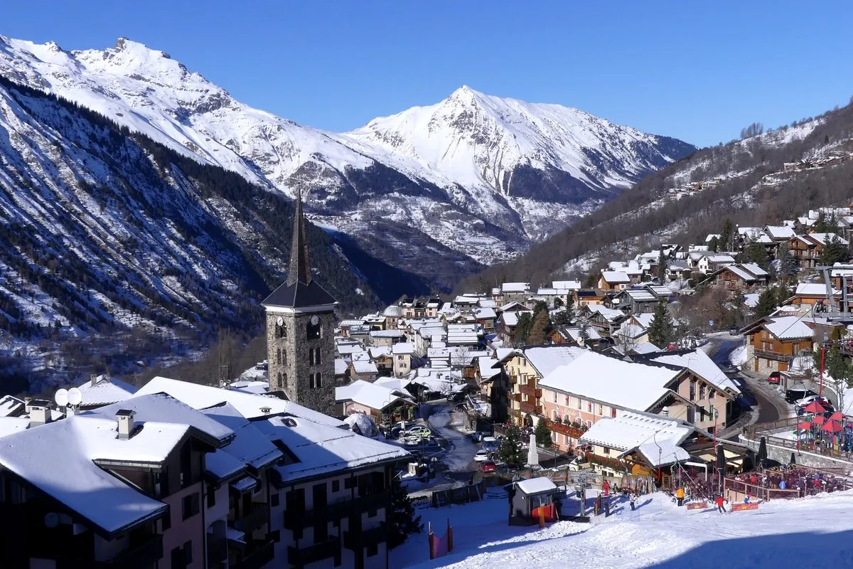 Saint-Martin-de-Belleville with its church tower and snowy mountains in December