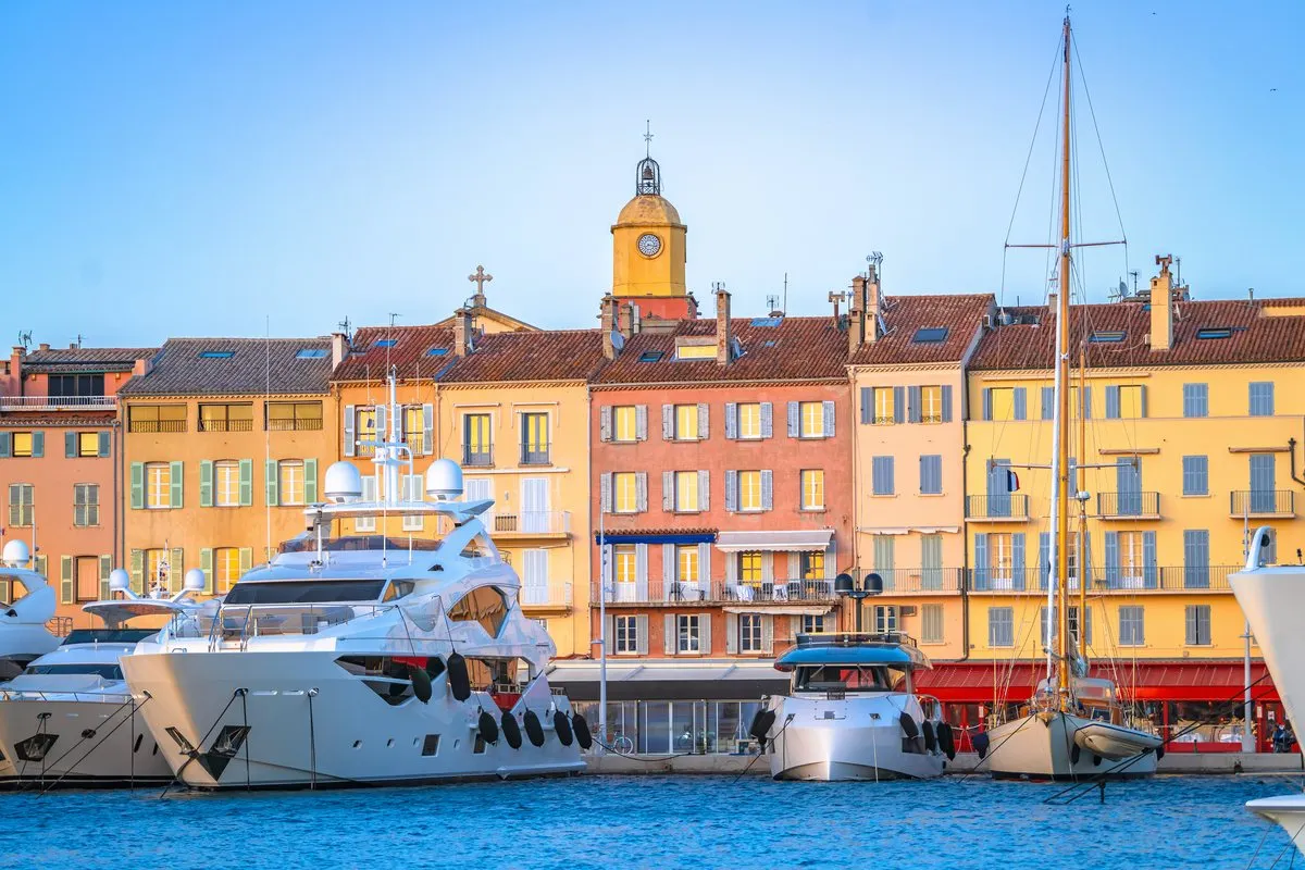 The old harbour of Saint-Tropez with pastel-coloured houses, the clock tower and yachts moored along the quay