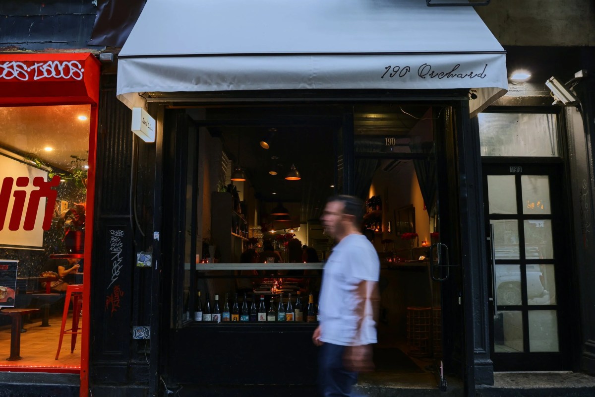 Restaurant storefront with 190 Orchard awning and dim interior visible through window