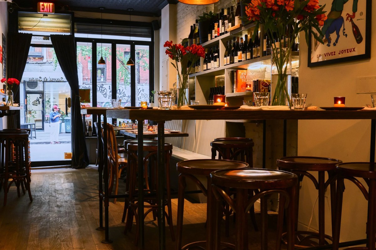 Interior view of dining room with bar stools, wine shelves, and door reading Sami & Susu