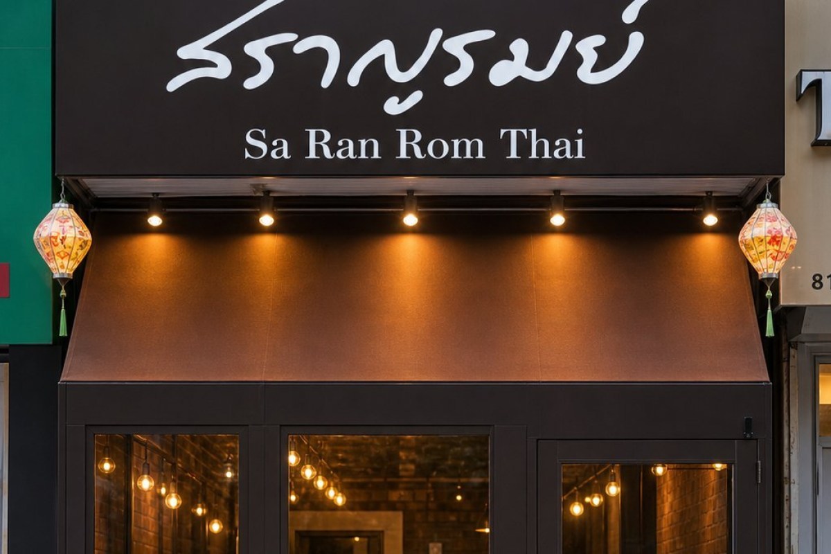 Restaurant exterior sign in Thai and English reading 'Sa Ran Rom Thai' above glass storefront with lanterns