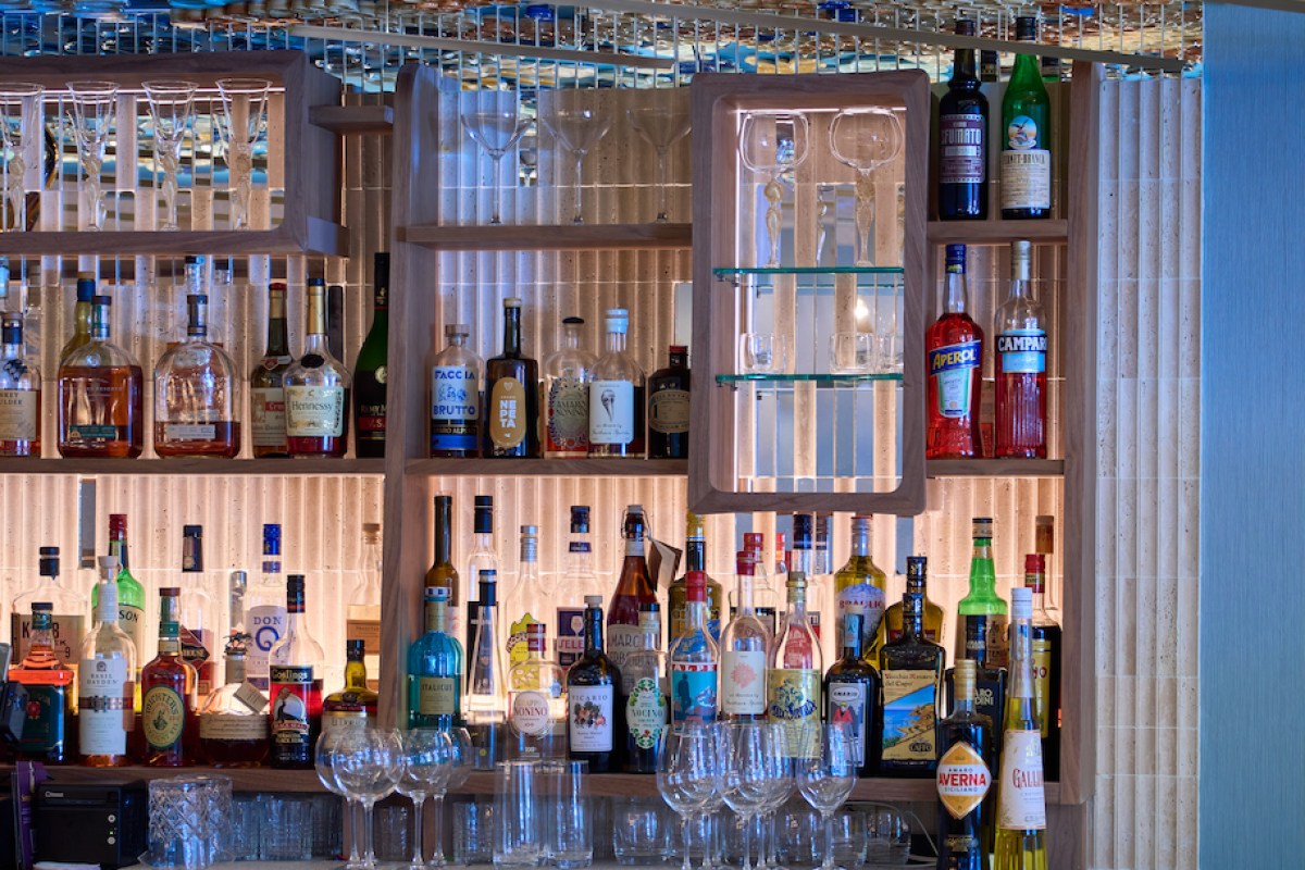 Close-up of the bar shelves stocked with liquor bottles and glassware