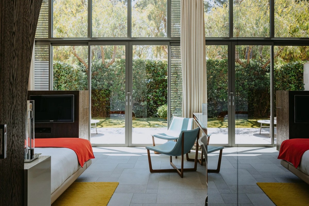 Twin bedroom with floor-to-ceiling windows overlooking garden