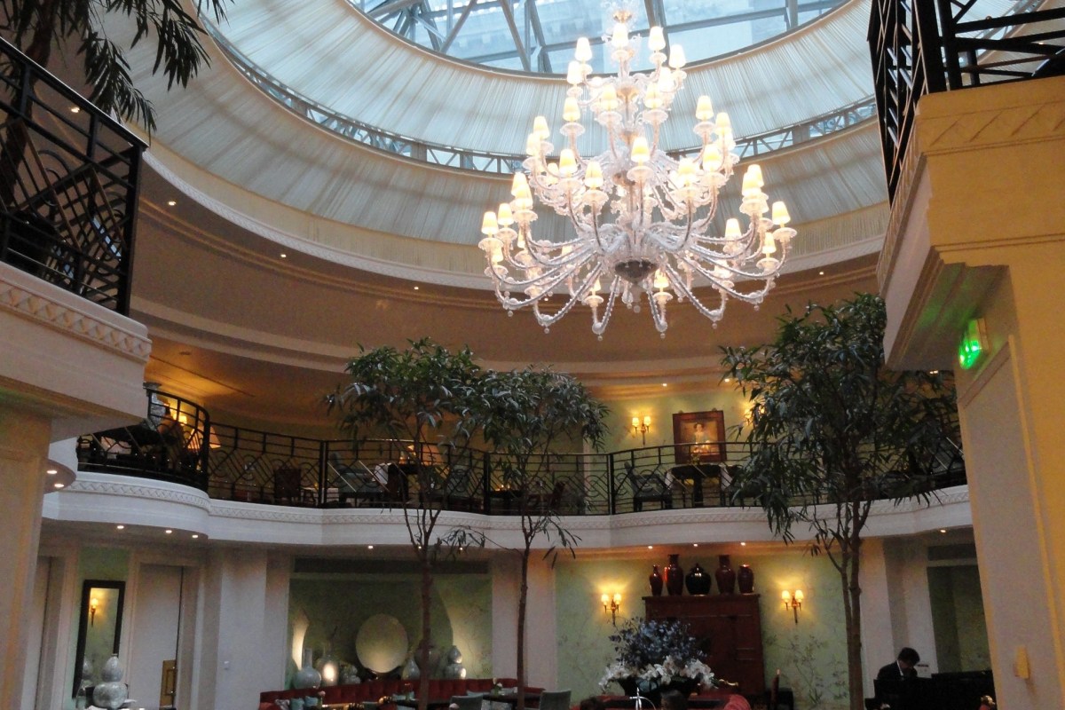 Interior atrium with glass dome skylight and large crystal chandelier, lounge seating below