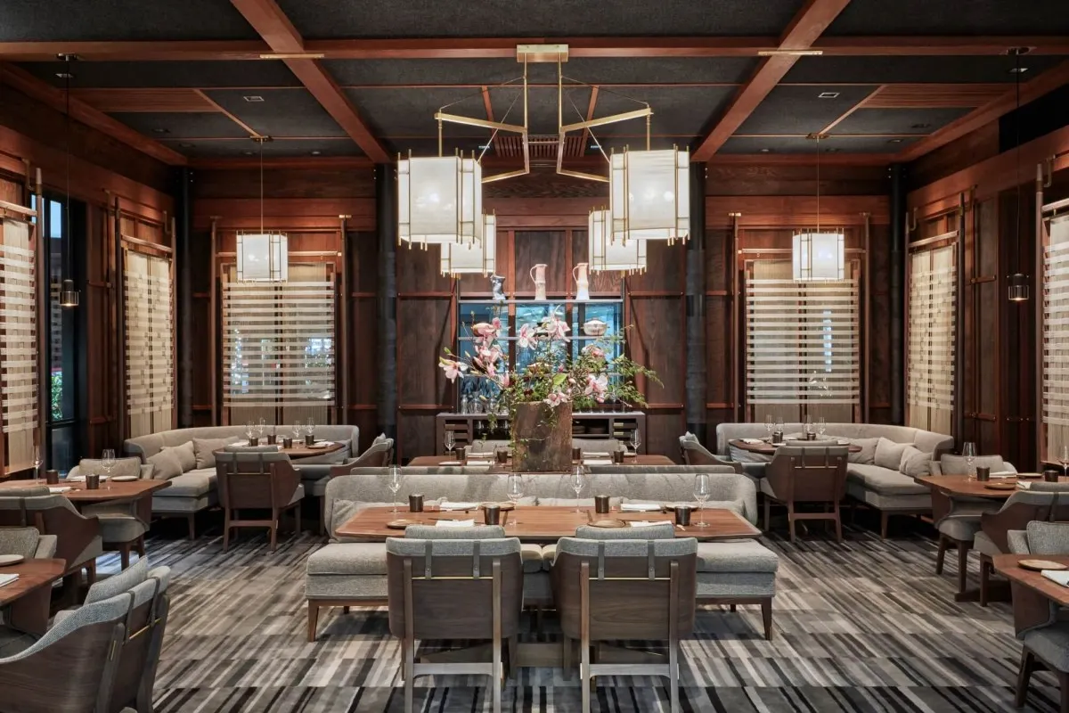Elegant dining room interior with wood beams, pendant lanterns, and lounge-style seating