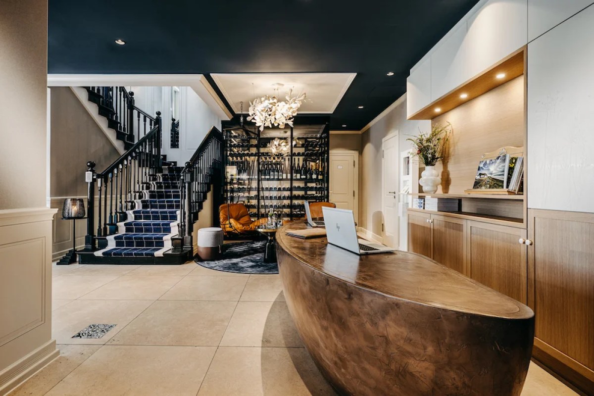 Hotel lobby with reception desk, staircase and wine display