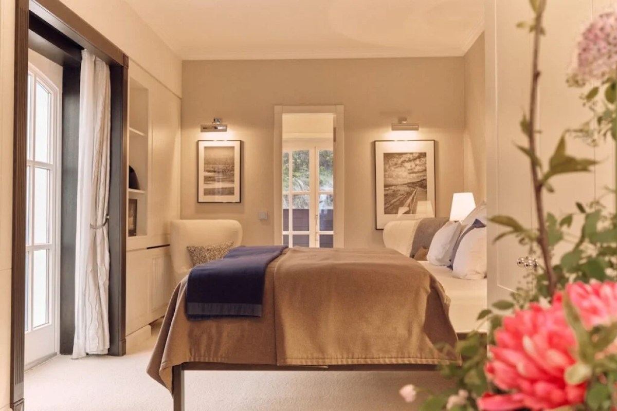 Guest bedroom with bed, artwork and balcony doors to garden