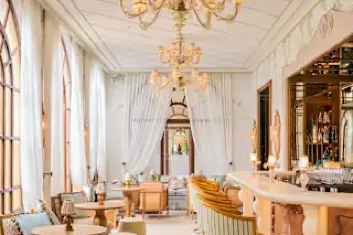 Elegant hotel lounge/bar with chandelier, sheer curtains, pastel seating