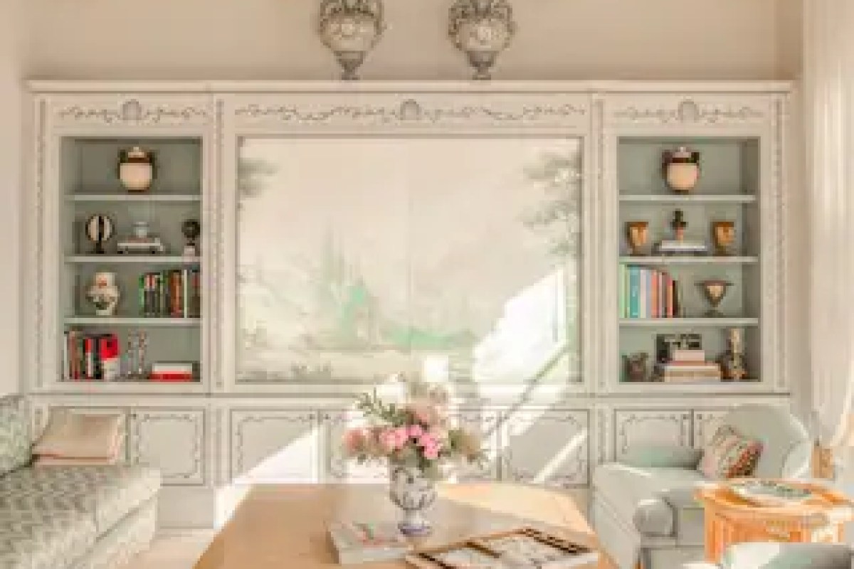 Elegant sitting room with painted cabinetry, bookshelves and floral arrangement