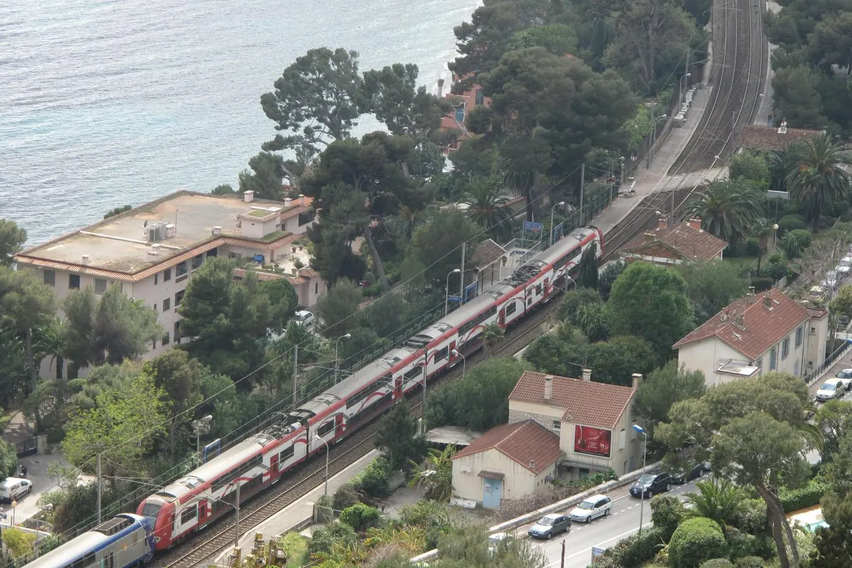 A regional train runs along the coast below the Chemin de Nietzsche at Èze-sur-Mer