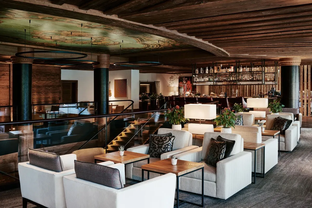 Hotel lounge and bar area with wood beams, armchairs and painted ceiling