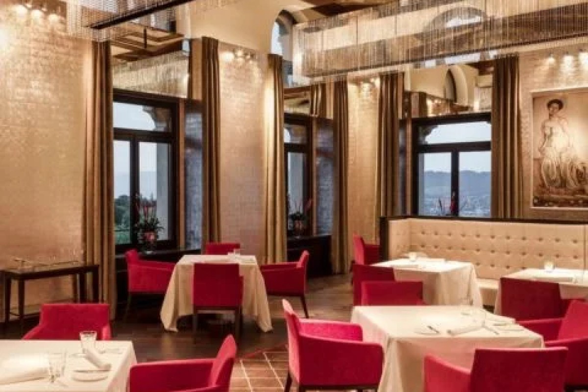 Elegant hotel restaurant with red chairs, white tablecloths and large windows showing valley view
