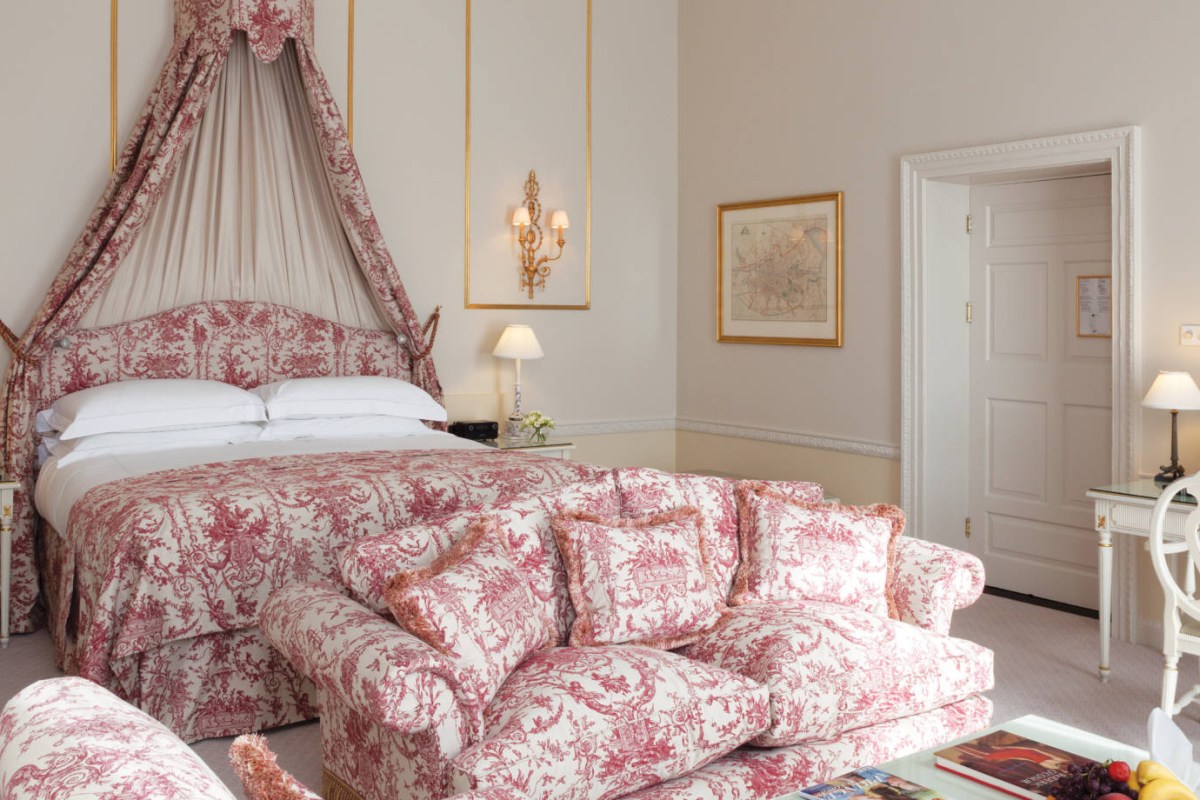 Guest room with canopy bed in red toile fabric and elegant decor