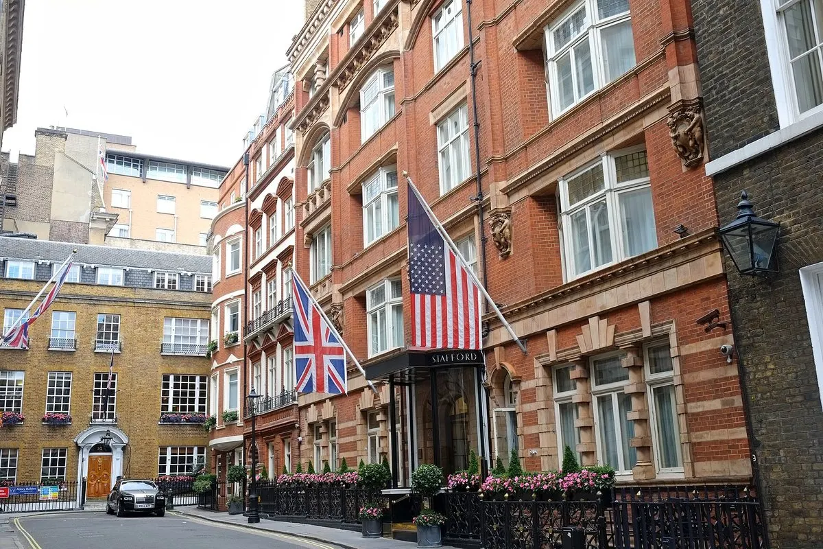 The red-brick façade of The Stafford on St James's Place, with the Union Flag and the Stars and Stripes over the entrance