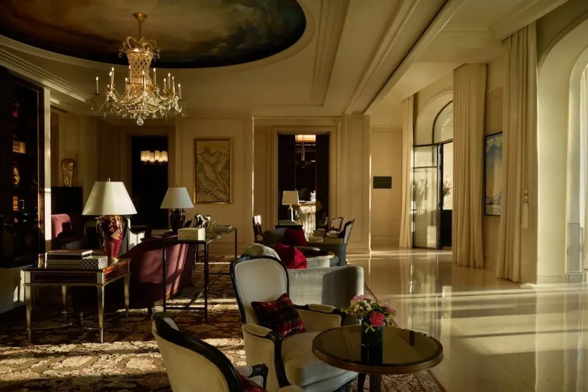 Elegant hotel lounge with chandelier, armchairs, and patterned carpet