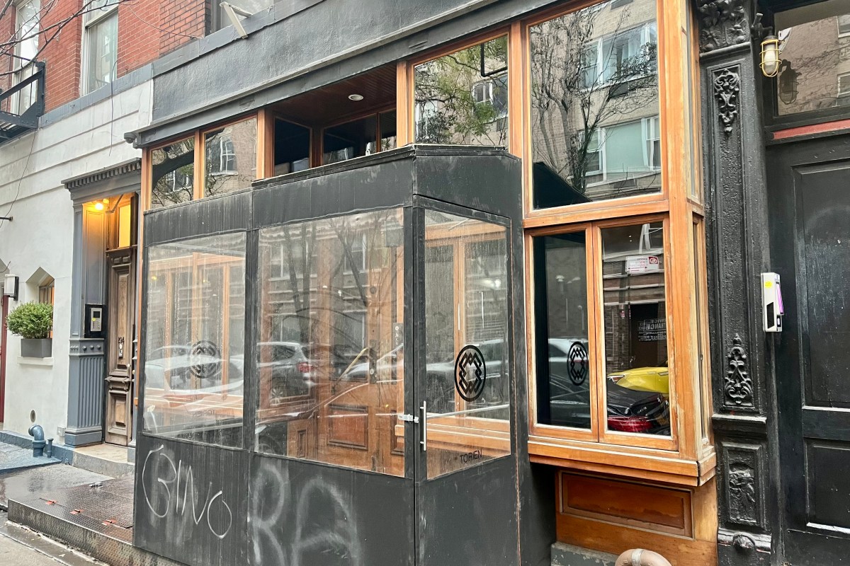 Exterior storefront of Torien restaurant in NYC, with black-framed windows and wood trim, logo on glass.