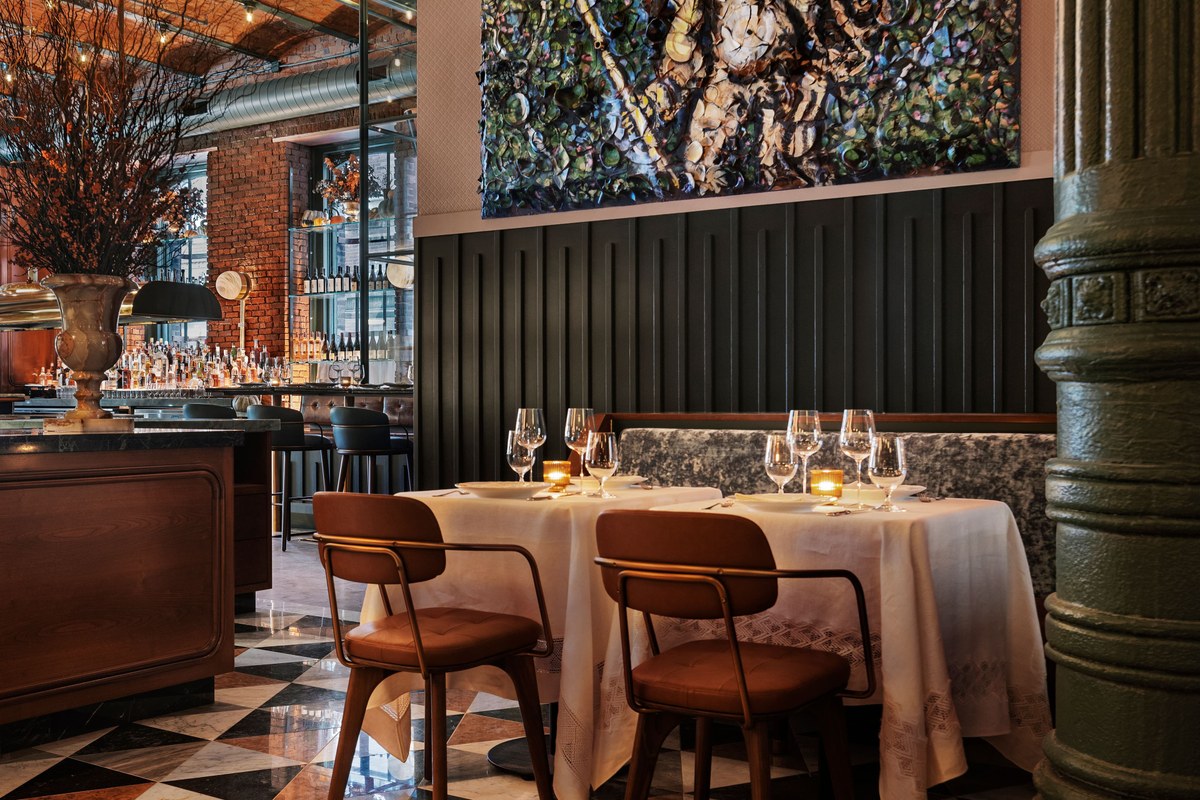 Table booth seating at Torrisi near the bar, with artwork on the wall
