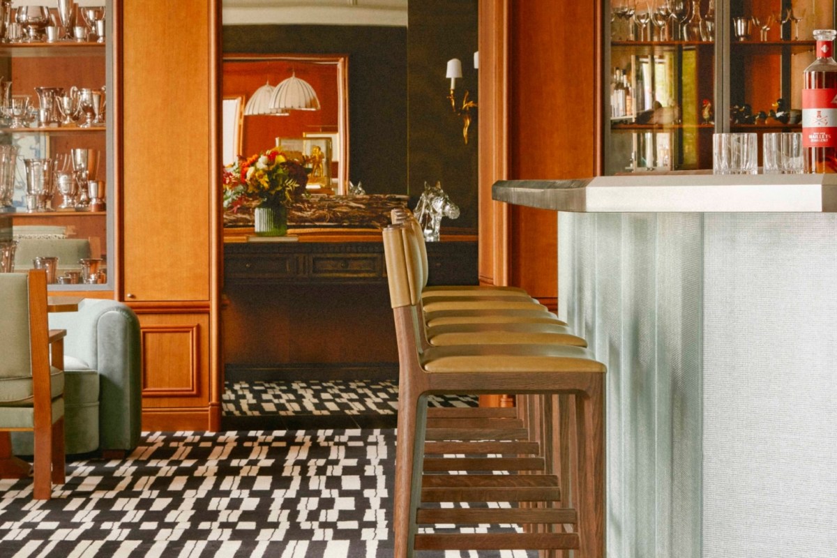 Restaurant bar area with leather stools, silver collection shelves and mirrored alcove