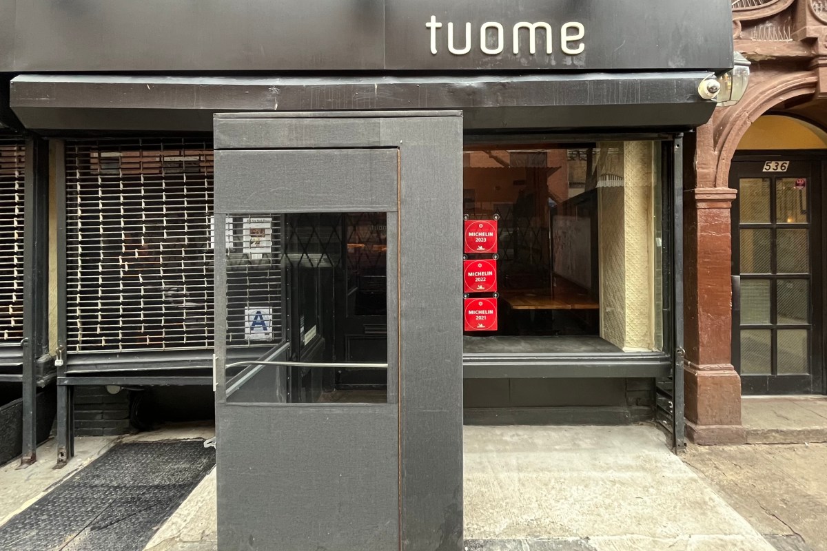 Exterior storefront of Tuome restaurant in NYC, showing entrance, signage, and Michelin stickers on the window.