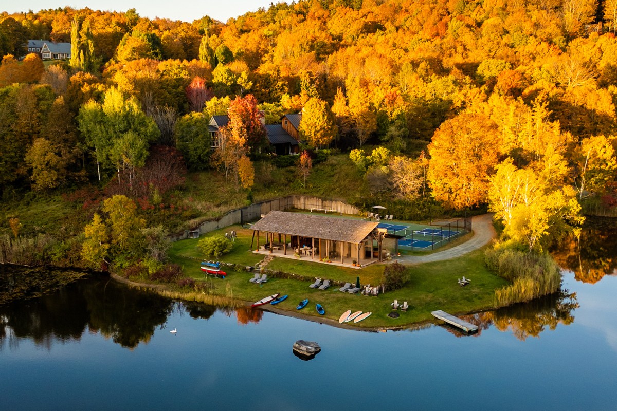 Aerial autumn view of Twin Farms lakeside pavilion with tennis courts and boats