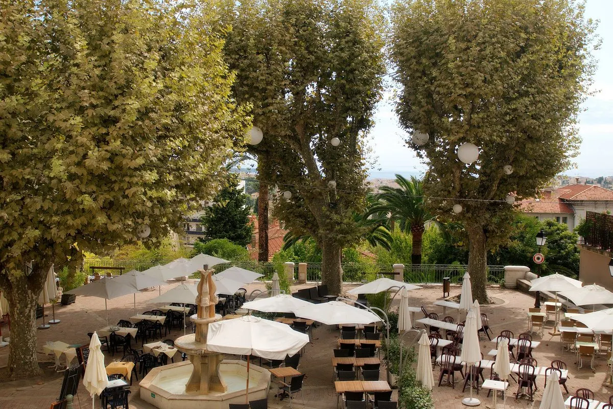 Outdoor terraces beneath the plane trees on rue Saint-Sauveur in Le Cannet's old village above Cannes