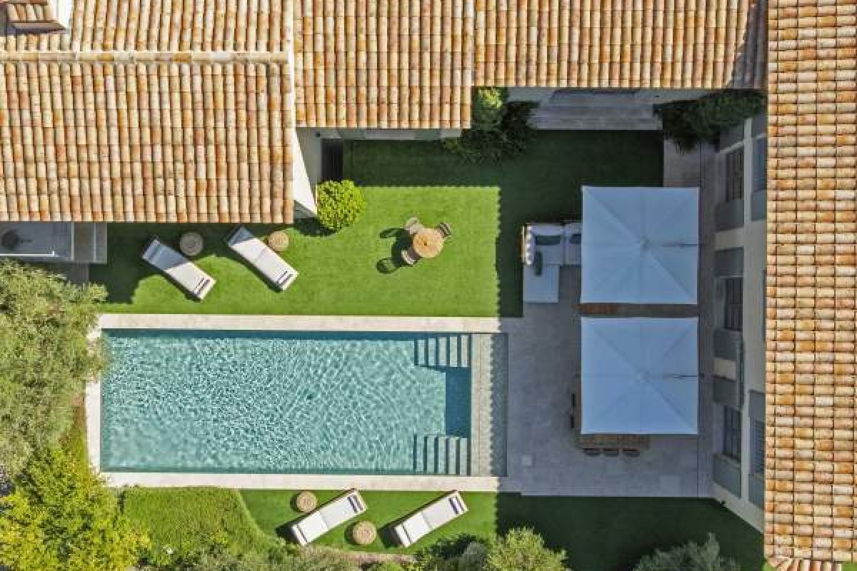 Aerial view of Villa Cosy's tiled rooftops, pool, and terrace with sun loungers