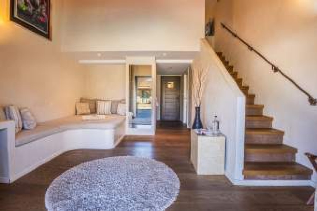 Hotel lobby area with wooden staircase, built-in bench seating, and polished wood floors