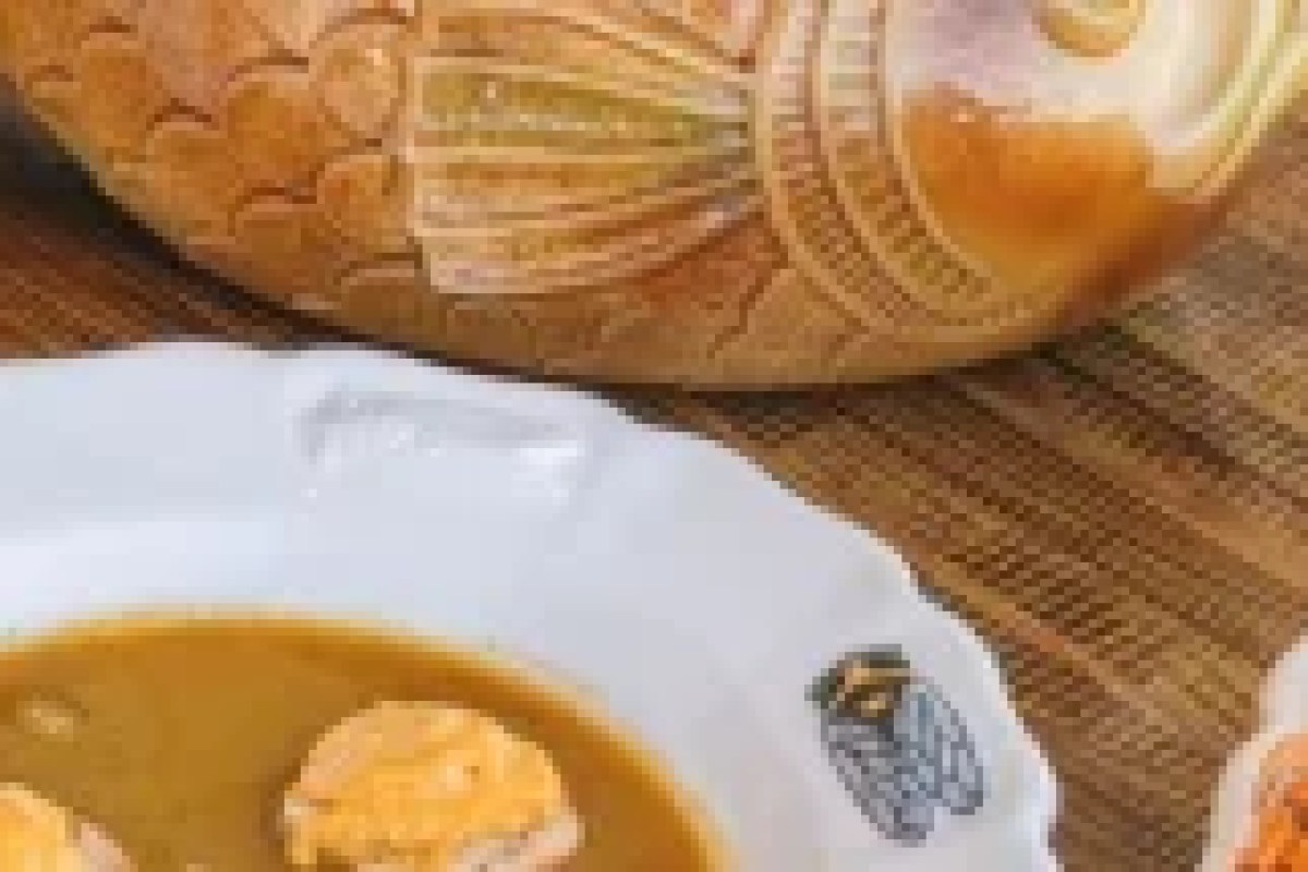 Close-up of a bowl of soup with crusty bread on a restaurant table