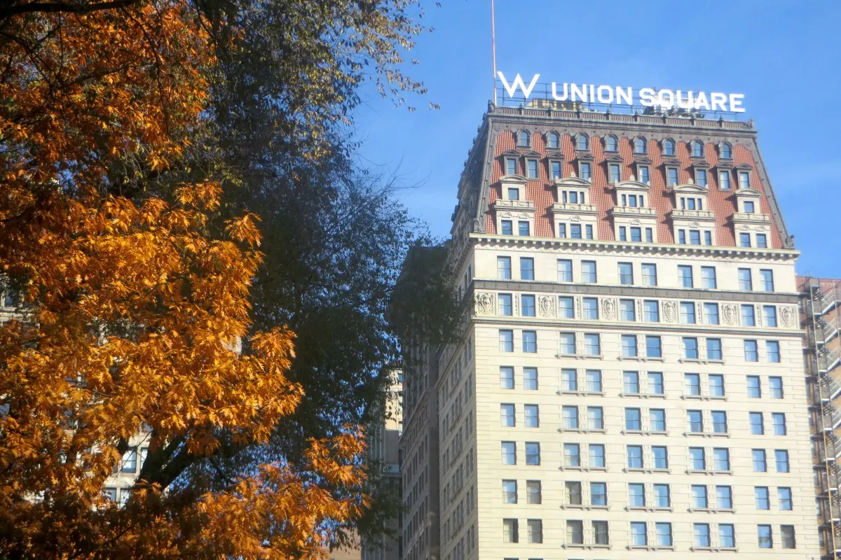 W Union Square hotel facade with rooftop sign, autumn tree in foreground