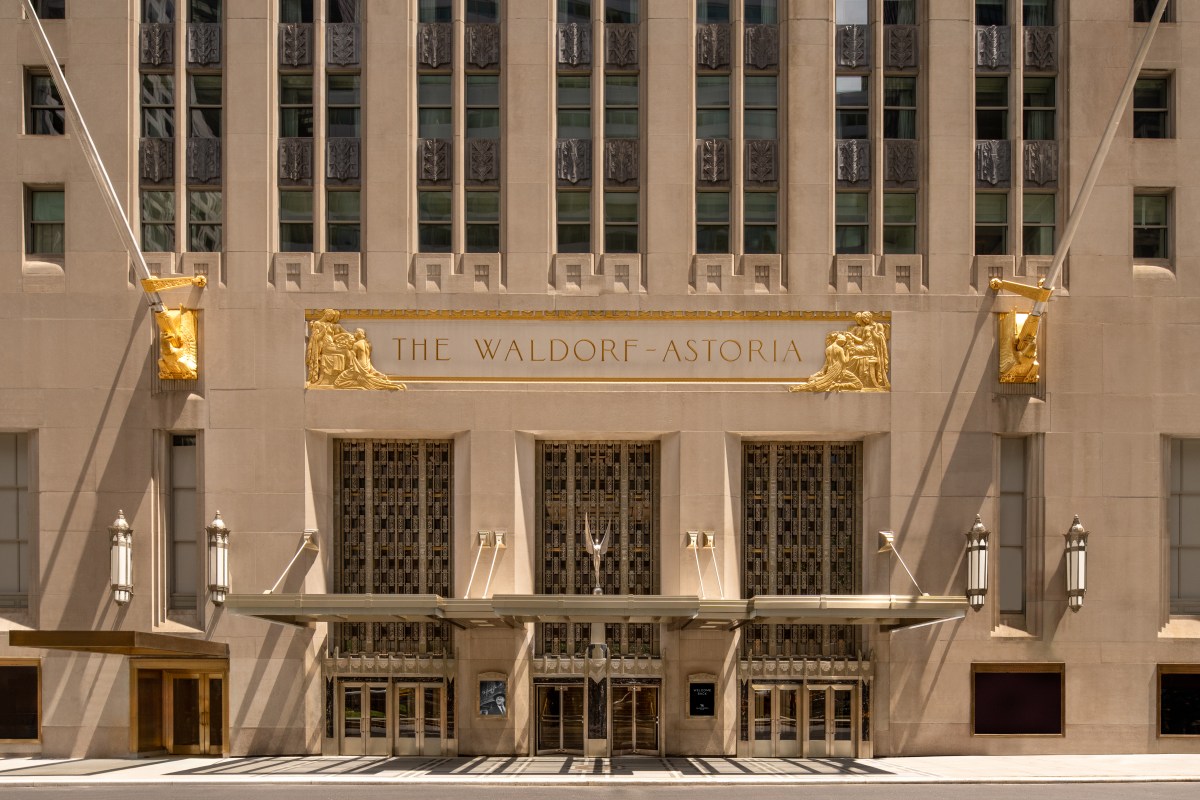 Art Deco facade of the Waldorf Astoria New York with golden signage and ornate entrance doors