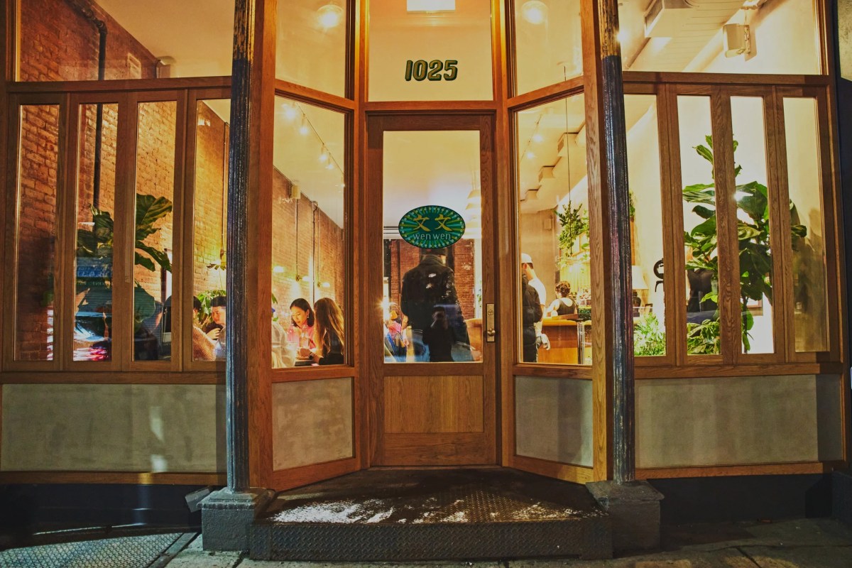 Wen Wen restaurant storefront entrance at night, glowing windows with wood framing and address 1025