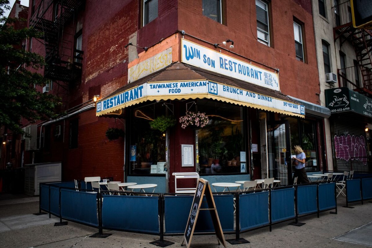 Exterior corner view of Win Son Restaurant storefront with sidewalk seating and awning signage