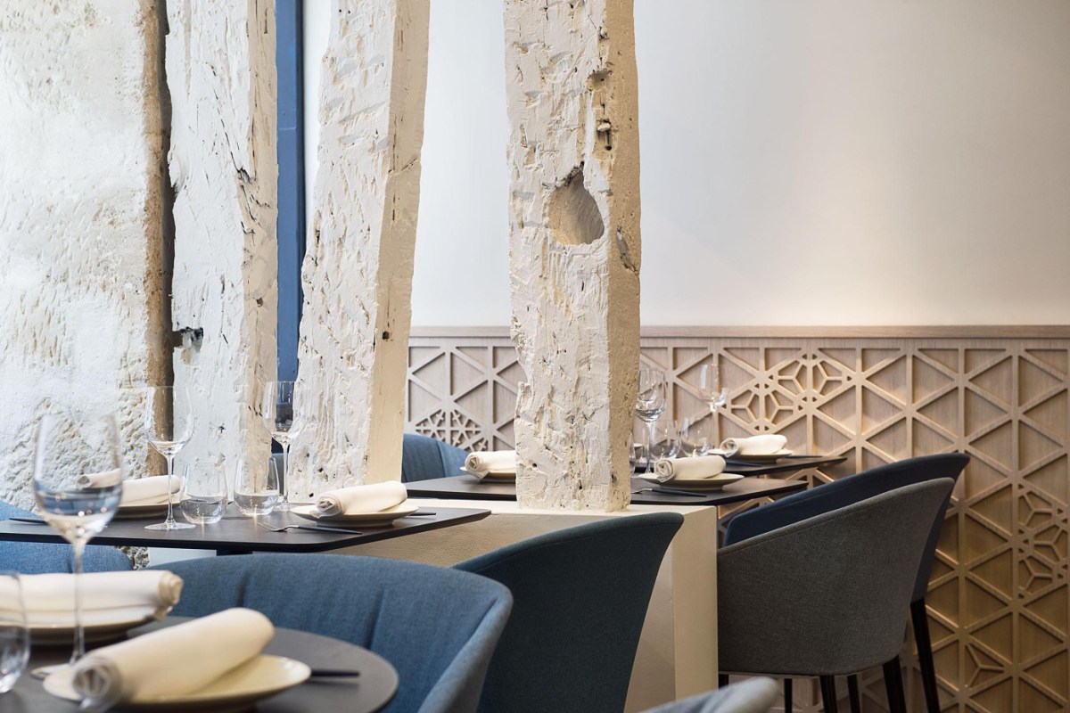 Close-up of dining room with white wooden beams and set tables