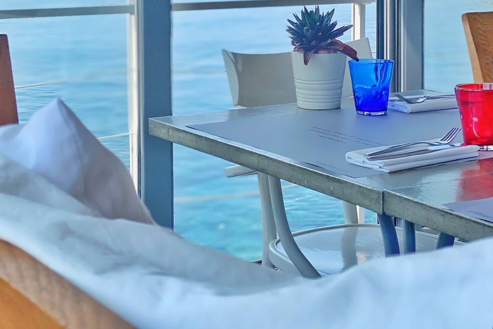 A table by the glass windbreak at Atrego with the open sea beyond, Cap-d'Ail